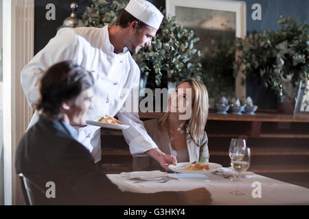 Küchenchef servieren Kunden im restaurant Stockfoto