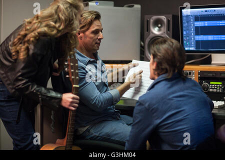 Musiker im Gespräch mit Musikproduzent im Musikstudio Stockfoto
