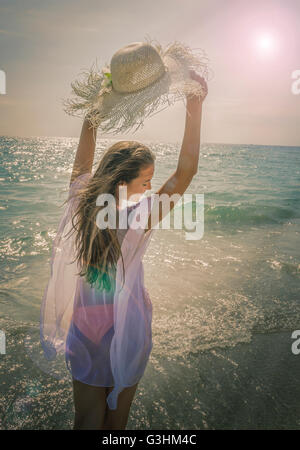 Schöne junge Frau hält Sonnenhut auf Miami Beach, Florida, USA Stockfoto