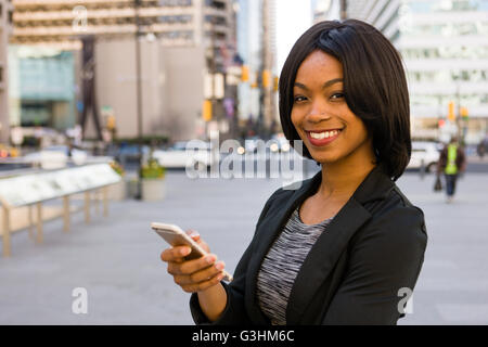 Porträt der Geschäftsfrau, Smartphone, Lächeln, draußen halten Stockfoto