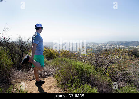 Mann am Berg tun Bein stretching-Übungen Stockfoto