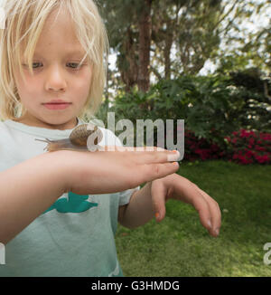 Blonde junge Holding Schnecke Stockfoto