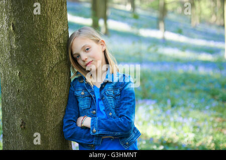 Porträt eines Mädchens lehnte sich gegen Baum in Bluebell Wald, Hallerbos, Brüssel, Belgien Stockfoto