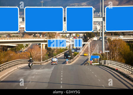 Autos auf der Autobahn mit leeren gerichteten Verkehrszeichen Stockfoto