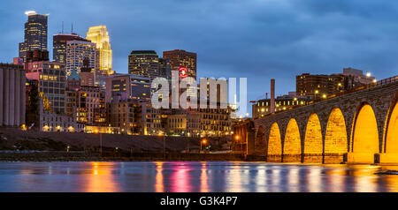 Skyline von Minneapolis, Minnesota und Stone Arch Bridge in der Dämmerung. Stockfoto