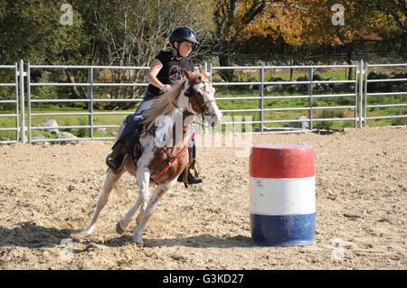 Junges Mädchen im Galopp um ein Fass in einem Fass-Rennen Stockfoto