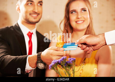 3 Personen verheiratet Paare Ausländer und Kellner Hotel Abendessen Giving Rechnungen Stockfoto