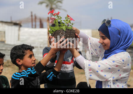 Gaza, Gaza. 24. März 2016. Palästinensische Kinder werden Pflanzen von Rosen und Blumen während einer Kundgebung fordern, ihre Häuser zu rekonstruieren, die 2014 im zweiten Weltkrieg in Schadschaija Nachbarschaft zerstört wurden. © Mohammed Al Hajjar/RoverImages/Pazifik Presse/Alamy Live-Nachrichten Stockfoto