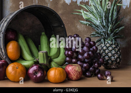 Frische Früchte in einem Korb auf einem Holzbrett gelegt. Stockfoto