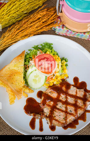 Rindersteak mit schwarzem Pfeffersauce, Salat und Pommes Frites auf Sack-Hintergrund Stockfoto