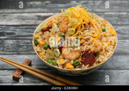 Chinesischer gebratener Reis mit Garnelen, Ei, Erbsen, Chinesisch Wurst und grüne Zwiebel gekocht. Auf Vintage chinesische Reisschüssel serviert. Stockfoto