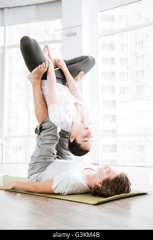 Junges Paar Acro Yoga-Übungen im Studio gemeinsam Stockfoto