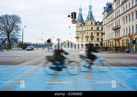 Zwei Radfahrer, die Beschleunigung auf blaue Stadt Radweg, Kopenhagen, Dänemark Stockfoto