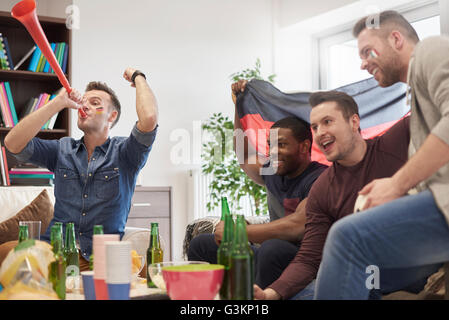 Gruppe von Männern beobachten Sportereignis im Fernsehen mit deutscher Flagge feiern Stockfoto