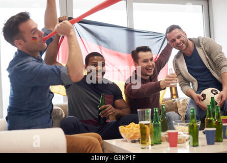 Gruppe von Männern beobachten Sportereignis im Fernsehen mit deutscher Flagge und Fußball, feiern Stockfoto