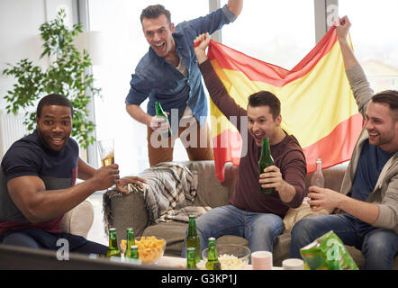 Gruppe von Männern beobachten Sportereignis im Fernsehen halten, spanische Flagge feiern Stockfoto