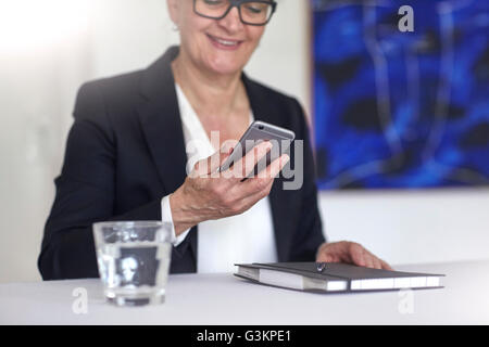 Frau lächelnd Smartphone betrachten Stockfoto