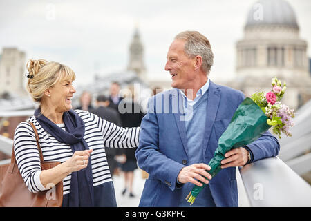 Romantische Reife dating paar Begrüßung bei der Millennium Bridge, London, UK Stockfoto