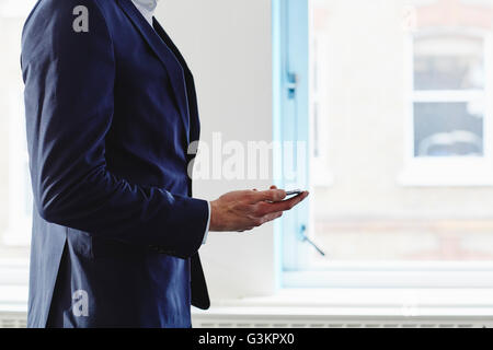 Seitenansicht der Mann Anzug hält Smartphone zugeschnitten Stockfoto