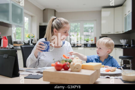 Mutter und Sohn sitzen am Tisch essen zusammen Stockfoto