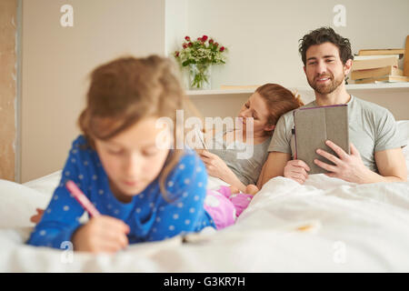 Mitte erwachsenes paar haben im liegen, während Tochter stützt sich auf Bett Stockfoto