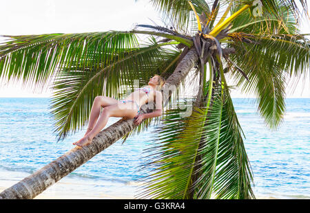 Junge Frau Sonnenbaden auf Palme am Strand, Dominikanische Republik, Karibik Stockfoto