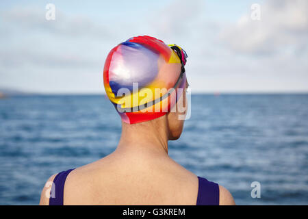 Reife Frau tragen Badesachen und Badehaube, neben dem Meer, Rückansicht Stockfoto