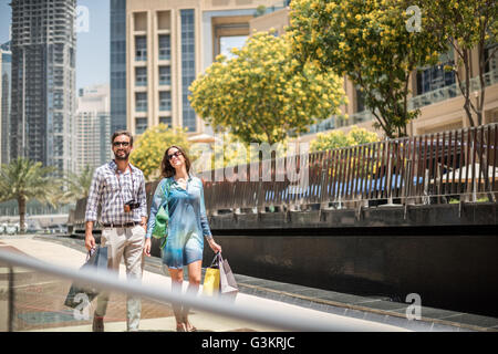 Paar spazieren am Gehweg Einkaufstaschen, Dubai, Vereinigte Arabische Emirate Stockfoto
