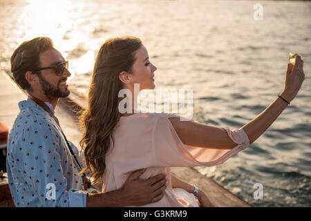 Romantisch zu zweit unter Smartphone Selfie auf Boot in Dubai Marina, Vereinigte Arabische Emirate Stockfoto