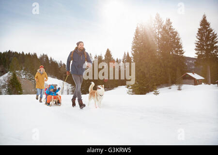 Eltern ziehen Söhne am Schlitten im Schnee bedeckt Landschaft, Elmau, Bayern, Deutschland Stockfoto