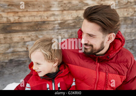 Junger Mann und Sohn in Hütte im Schnee, Elmau, Bayern, Deutschland Stockfoto