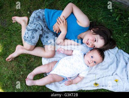 Draufsicht der jungen und Baby Bruder im Garten liegen Stockfoto