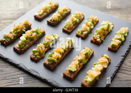 Guacamole, Räucherlachs und Roggenbrot Kanapees Stockfoto