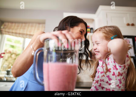 Mutter und Tochter machen Smoothies in lauten Mixer Stockfoto