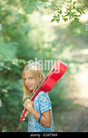 Porträt eines Mädchens mit roten Ukulele in Wäldern, Buonconvento, Toskana, Italien Stockfoto