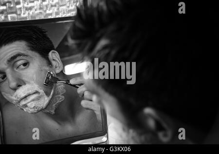 Mann im Spiegel mit Bürste, Creme und Rasierer Nassrasur Stockfoto