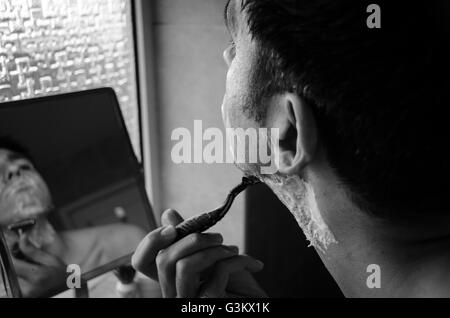 Mann im Spiegel mit Bürste, Creme und Rasierer Nassrasur Stockfoto