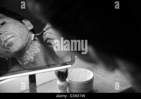 Mann im Spiegel mit Bürste, Creme und Rasierer Nassrasur Stockfoto