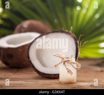 Kokosnüsse und Kokosöl auf Holztisch, auf Natur Hintergrund Stockfoto