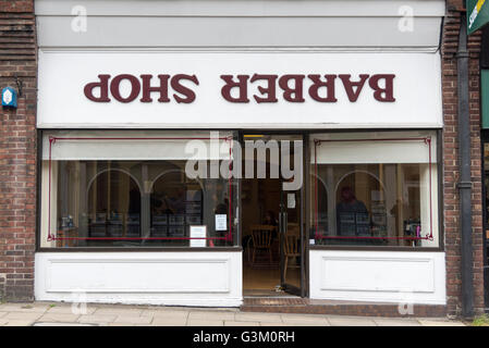 Eine Barbers Shop in Winchester UK mit dem Zeichen auf dem Kopf stehend Stockfoto