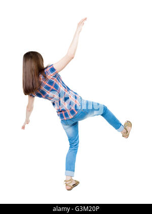 Rückansicht Salden schwenkte die arme Frau. Junges Mädchen in Jeans stehen. Hintere Ansicht Menschen Sammlung. Rückseite Blick auf Person. Isoliert auf weißem Hintergrund. Ein junges Mädchen in einem karierten blau mit roten Streifen fällt auf seinem zurück auf sein linkes Bein balancieren. Stockfoto