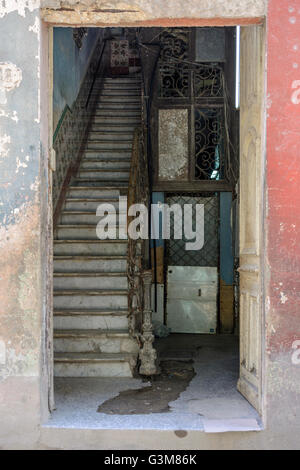 Eine offene Tür auf ein altes Haus enthüllt die dunklen Innenraum und Treppen, Alt-Havanna, Kuba Stockfoto