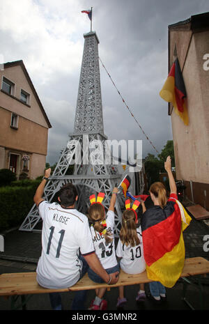 Duisburg, Deutschland. 13. Juni 2016. ILLUSTRATION - Sina (2 L) und Schwester Leonie (2-R) und ihre Eltern Stephanie (R) und Torsten Goebbels posieren vor einem Eiffelturm Modell in Duisburg, Deutschland, 13. Juni 2016. Das Haus der Familie ist auf der rechten Seite abgebildet. Die Familie Uhren die live-Übertragung der UEFA Euro 2016 mit Nachbarn in einem Zelt, wenn die deutsche Fußball-Nationalmannschaft spielt. Foto: ROLAND WEIHRAUCH/Dpa/Alamy Live News Stockfoto