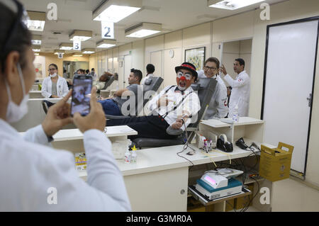 (160614) - SAO PAULO, 14. Juni 2016 (Xinhua)--Bild aufgenommen am 9. Juni 2016 zeigt eine Krankenschwester die Fotos von Gilberto Kido (C), 50, dabei eine Freiwillige Blutspende am "Sangre Stiftung Pro" in Sao Paulo, Brasilien. Gilberto Kido wurde ein freiwilliger Blutspender für die letzten 30 Jahre nach dem Tod seiner Mutter während der Wartezeit für eine Nierentransplantation. Mit seinem Clown-Charakter, hat Kido ein Ziel, das Blutspenden zur Rettung von Menschenleben zu fördern. Der Weltblutspendetag wird jährlich am 14. Juni gefeiert. Im Jahr 2016 das Thema der Kampagne ist "Blut verbindet uns alle", die Welt-Gesundheit-Organi Stockfoto