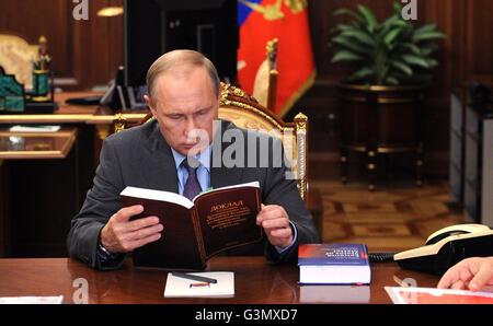 Moskau, Russland. 14. Juni 2016. Der russische Präsident Vladimir Putin Bewertungen ein Buch bei einem Treffen mit Präsident der russischen Akademie der Wissenschaften Vladimir Fortov und Direktor der Bundesanstalt für wissenschaftliche Organisationen Mikhail Kotyukov im Kreml 14. Juni 2016 in Moskau, Russland. Bildnachweis: Planetpix/Alamy Live-Nachrichten Stockfoto