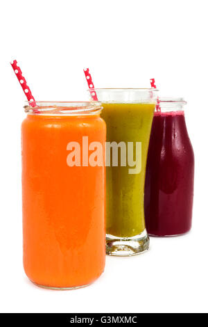Nahaufnahme von drei verschiedenen frischen Smoothies serviert in einem Glas, ein Glas und eine Flasche aus Glas mit roten Trinkhalme gemustert Stockfoto