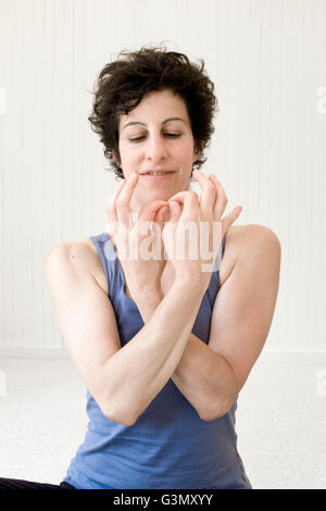 Frauen Yoga Praktizierenden eine Mudra (Handhaltung) im Studio durchführen Stockfoto