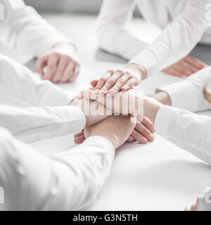 Geschäftsleute, die sich die Hand im Stapel Nahaufnahme Stockfoto