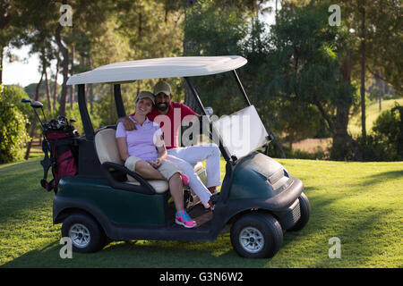 paar im Buggy Warenkorb auf Golfplatz Stockfoto