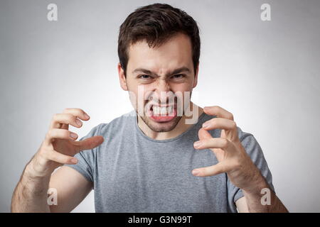 Zorniger junger Mann ballte seine Zähne bereit zum Sprung Stockfoto